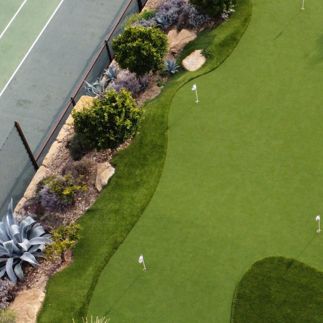 Aerial view of a Riviera Grass synthetic green integrated with desert landscaping in the UAE
