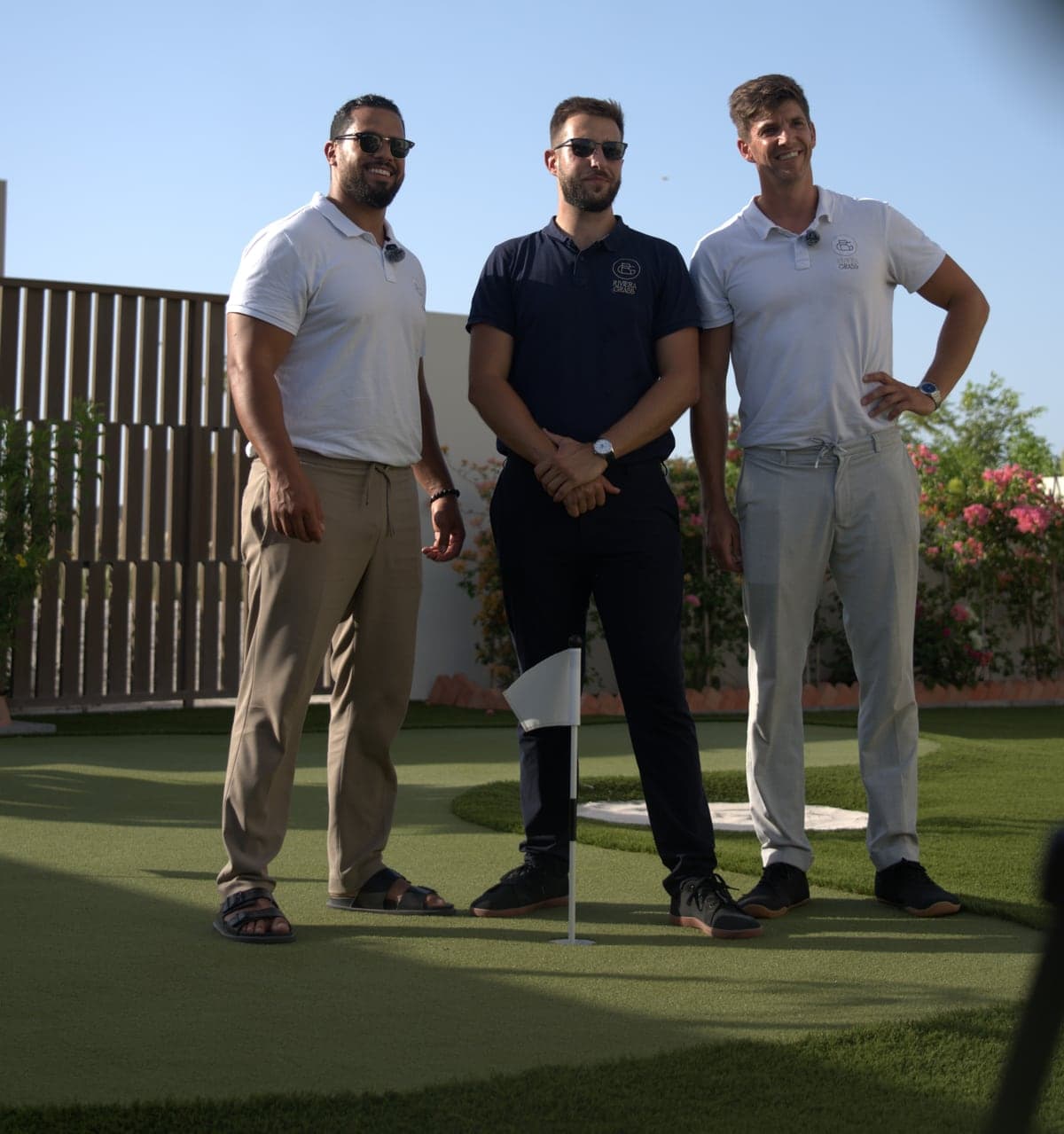 The three Riviera Grass founders standing on a private putting green in the UAE
